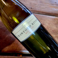 A bottle of Crawford River 2024 vintage Riesling, angled diagonally on a rustic wooden surface.